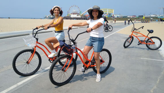 2 women on bicycles at the beach