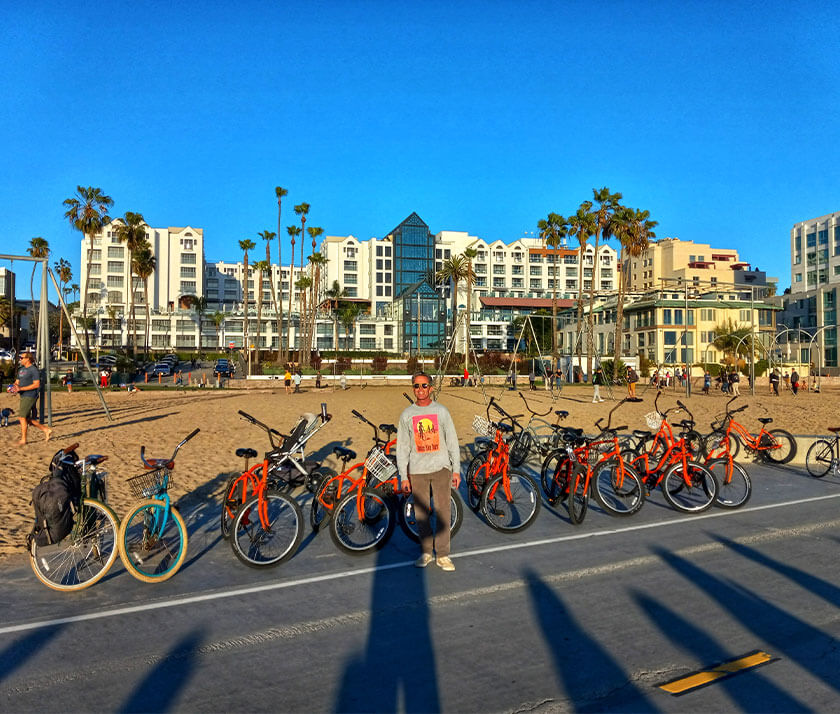 man at the beach with a lot of bikes behind him